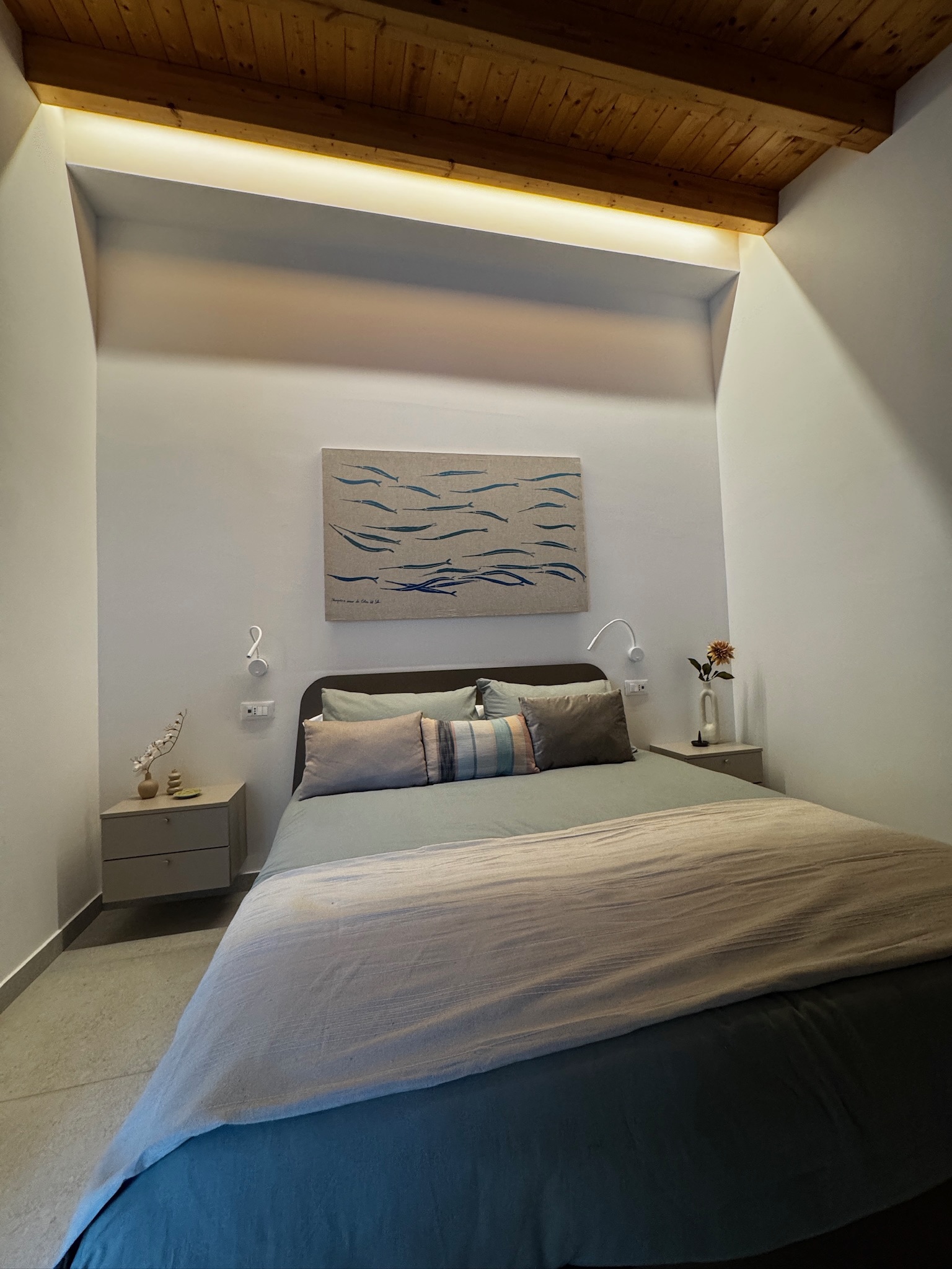 Studio Secondo bedroom with exposed wood-beam ceiling